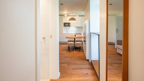 Una cocina moderna con armarios blancos, una mesa de comedor y sillas.