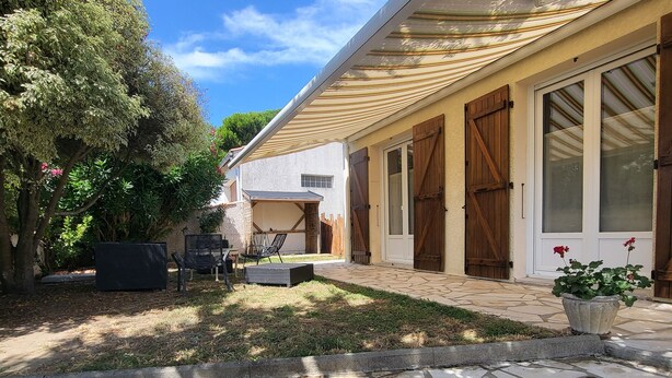 A covered patio area with a stone floor, a wooden fence, and a potted plant. - Family home in Fouras - enclosed garden near beach and market  (Fouras)