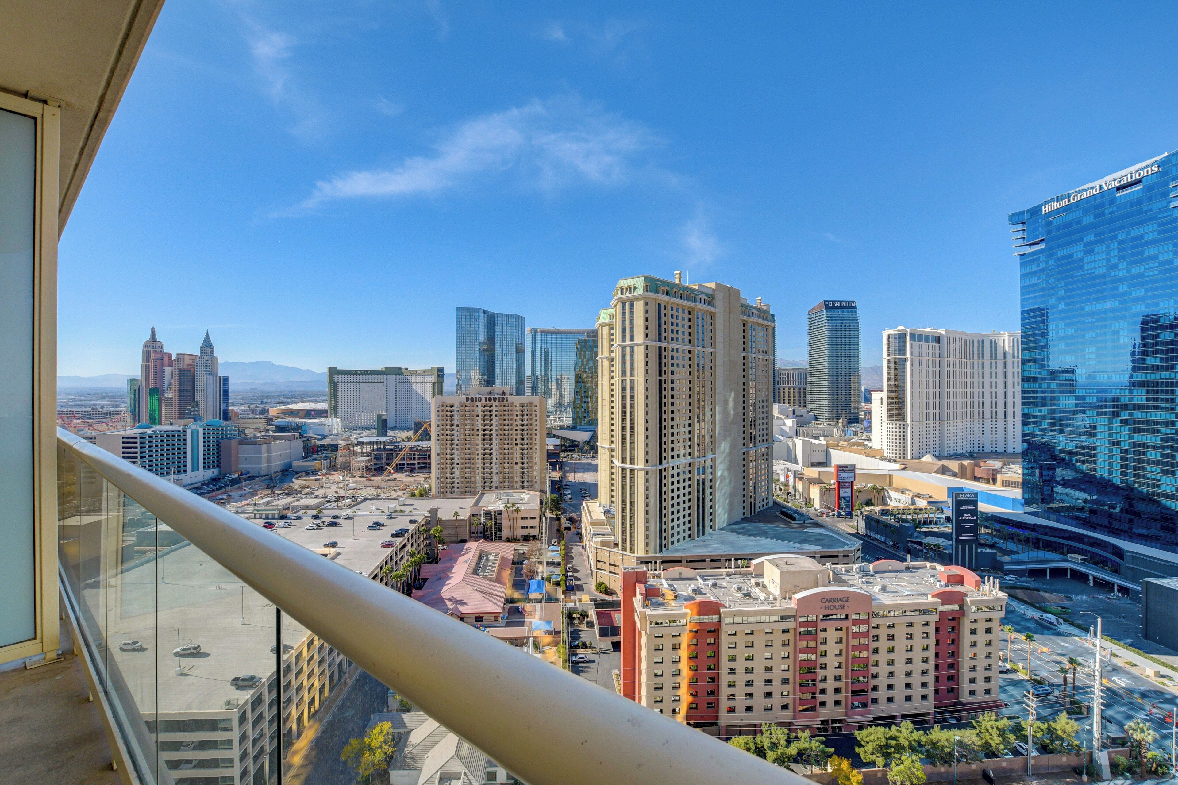 A high-rise hotel with a view of a cityscape, including other buildings and a parking area.