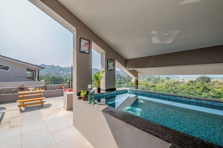 Una piscina al aire libre, sillones reclinables de piscina