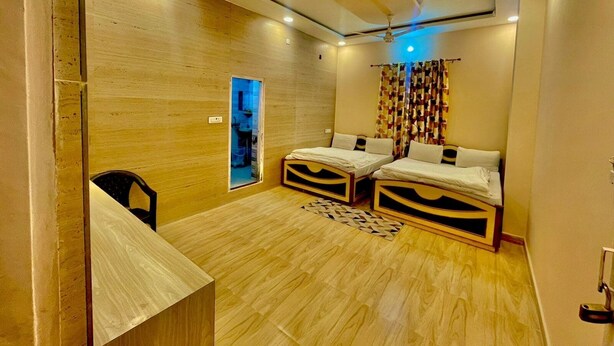 A room with two beds, a ceiling fan, and a small desk. - Sunrise Hotel & Restaurant (Danta Ramgarh)