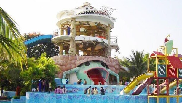 A water park with a large slide, a wave pool, and a multi-level play structure. - Pragati Resorts (Shankarpalle)