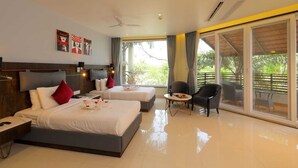 A hotel room with two beds, a small table, a chair, and a balcony with a view of greenery. - Pragati Resorts (Shankarpalle)