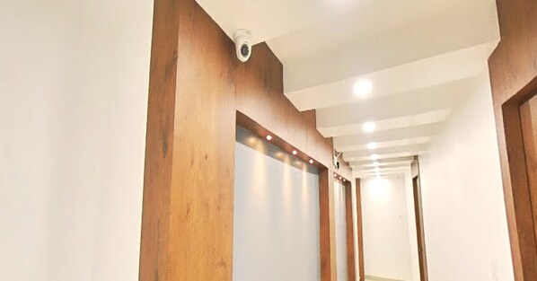 A hallway with wooden paneling and recessed lighting.