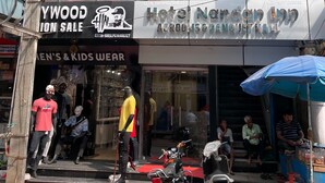 A hotel with a modern glass facade, a red carpet entrance, and a motorcycle parked outside. - Hotel Nandan Inn (Gaya)