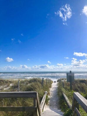 A wooden boardwalk leading to the beach with a sign warning of no lifeguard on duty and swim at own risk. - Surf Shack - Classic PCB - Steps to Beach Access (Panama City Beach)