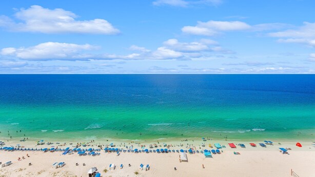 Een strand met helder turquoise water en een zandstrand.