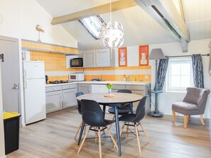 A compact kitchen with a microwave, toaster, and orange-tiled backsplash. - Le Pré d'Olonne (L'Île-d'Olonne)