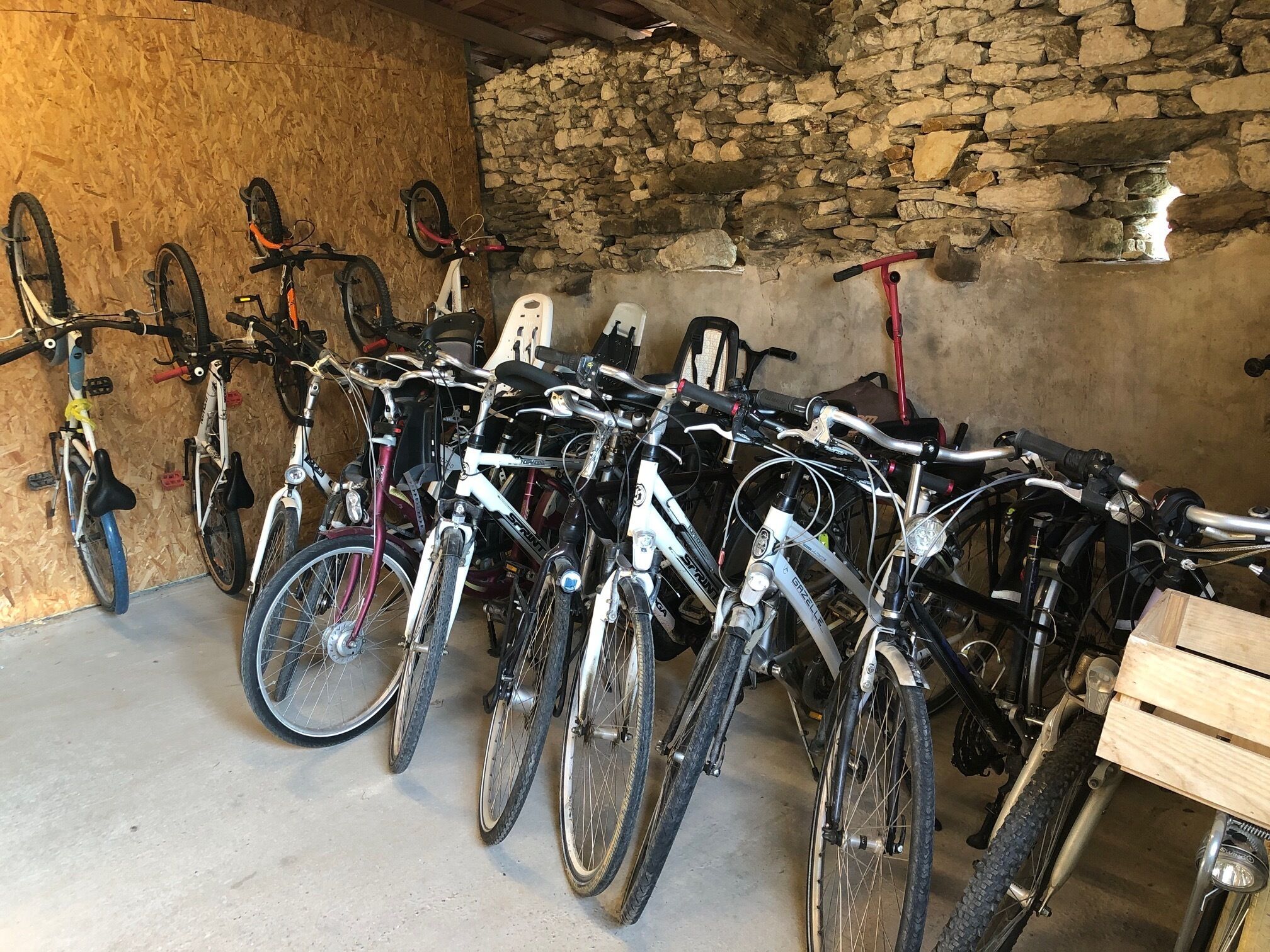 Een kamer met stenen muren en fietsen die tegen de muur staan.