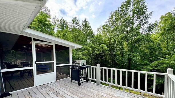 A wooden deck with a grill and outdoor seating.
