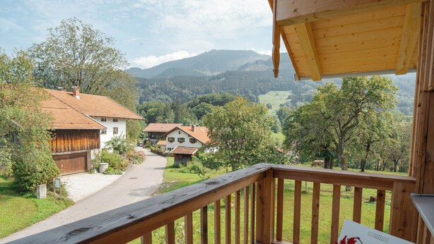 Eine Holterrasse mit Blick auf ein Dorf und Berge.