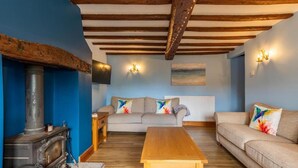 Una sala de estar acogedora con una mesa de madera, dos sofás y una chimenea.
