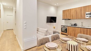 Un apartamento moderno con kitchenette, comedor y sala de estar.