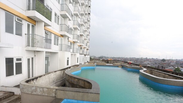 A residential building with a swimming pool. - Capital O Iconic Rooms @ Golden City (Bekasi)