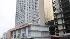 A high-rise building with multiple floors and balconies, a sign reading "Hyundai Park," and a partially constructed building to the right. - Capital O Iconic Rooms @ Golden City (Bekasi)