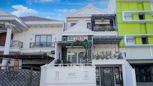 A hotel with a prominent 'PURI INN' sign, a balcony with plants, and a visible entrance. - OYO 94669 Hotel Puri Inn Panakkukang Makassar (Makassar)