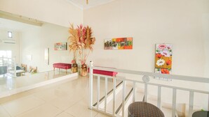A spacious lobby with a high ceiling, a modern chandelier, and a staircase with a white railing. - OYO 94669 Hotel Puri Inn Panakkukang Makassar (Makassar)