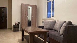 Una sala de estar con una mesa de madera, un sofá gris y una ventana con vistas.