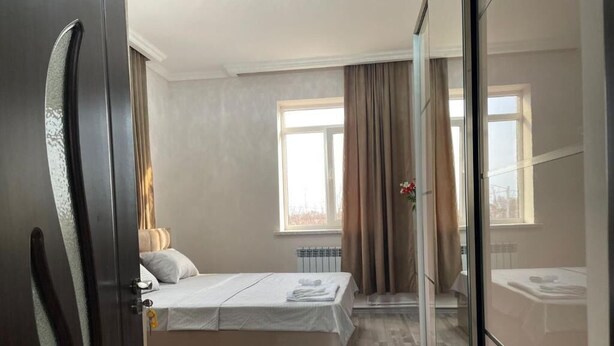 Un dormitorio moderno con cama, una silla y un separador de vidrio.