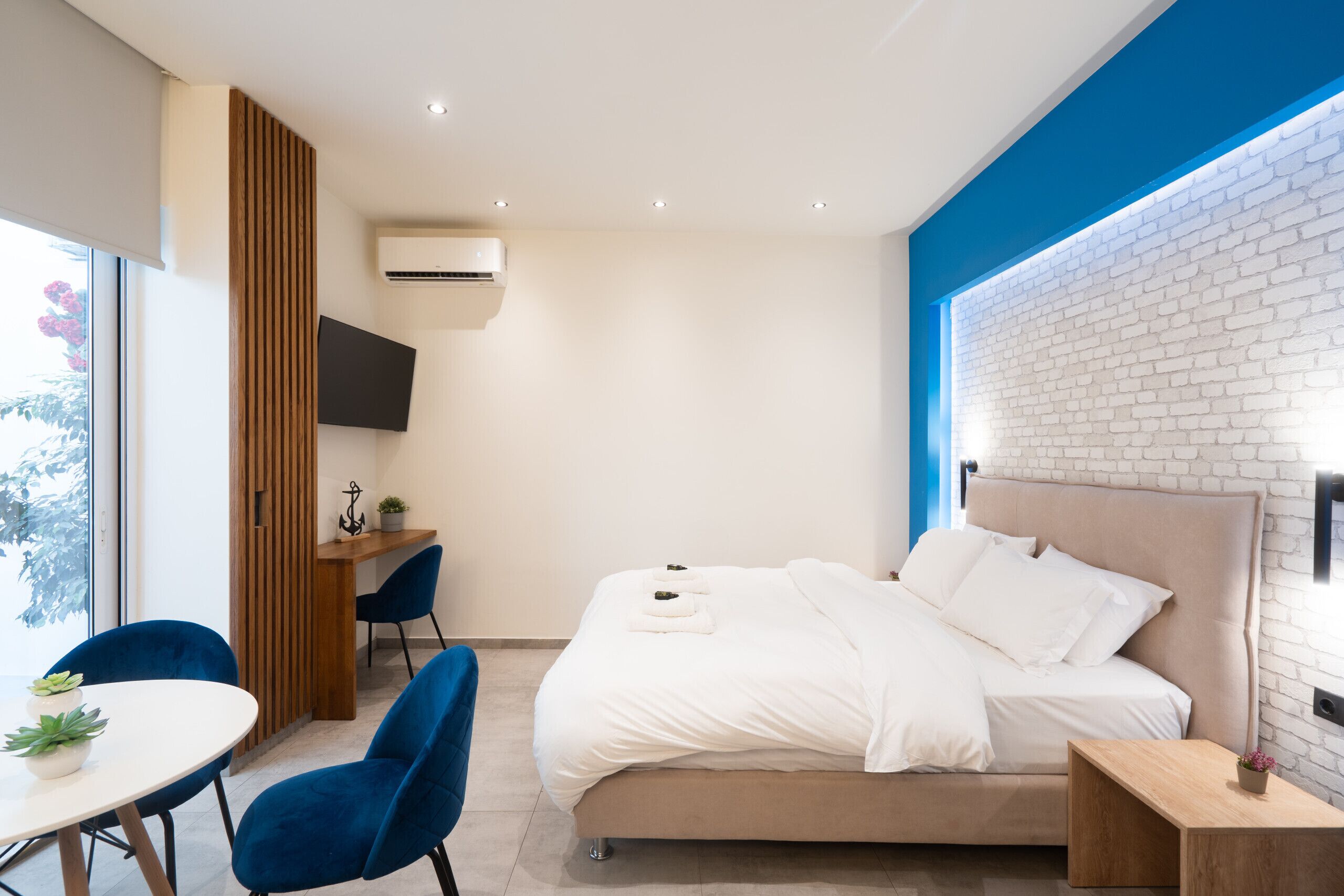 Une chambre moderne avec un grand lit, un bureau et une télévision.