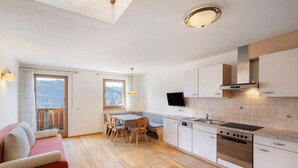 Una cocina moderna con comedor, piso de madera y un sofá.