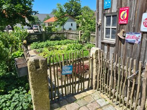 A garden with a wooden fence, a closed sign, and Coca-Cola and Pepsi signs. - Glamping 'Rosenzauber' with Shared Pool, Wi-Fi and Air Conditioning (Münchberg)