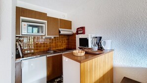 A compact kitchen with a microwave, coffee maker, and a small TV. - Isabella IS65 VIEW & CENTER 4 Pers. (Châtel)