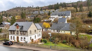 Ein Wohngebiet mit Häusern, einer Straße und einer Erhebung im Hintergrund.