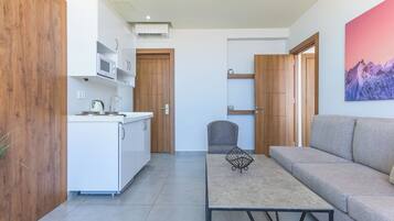 A compact living space with a kitchenette, a sofa, and a dining table.