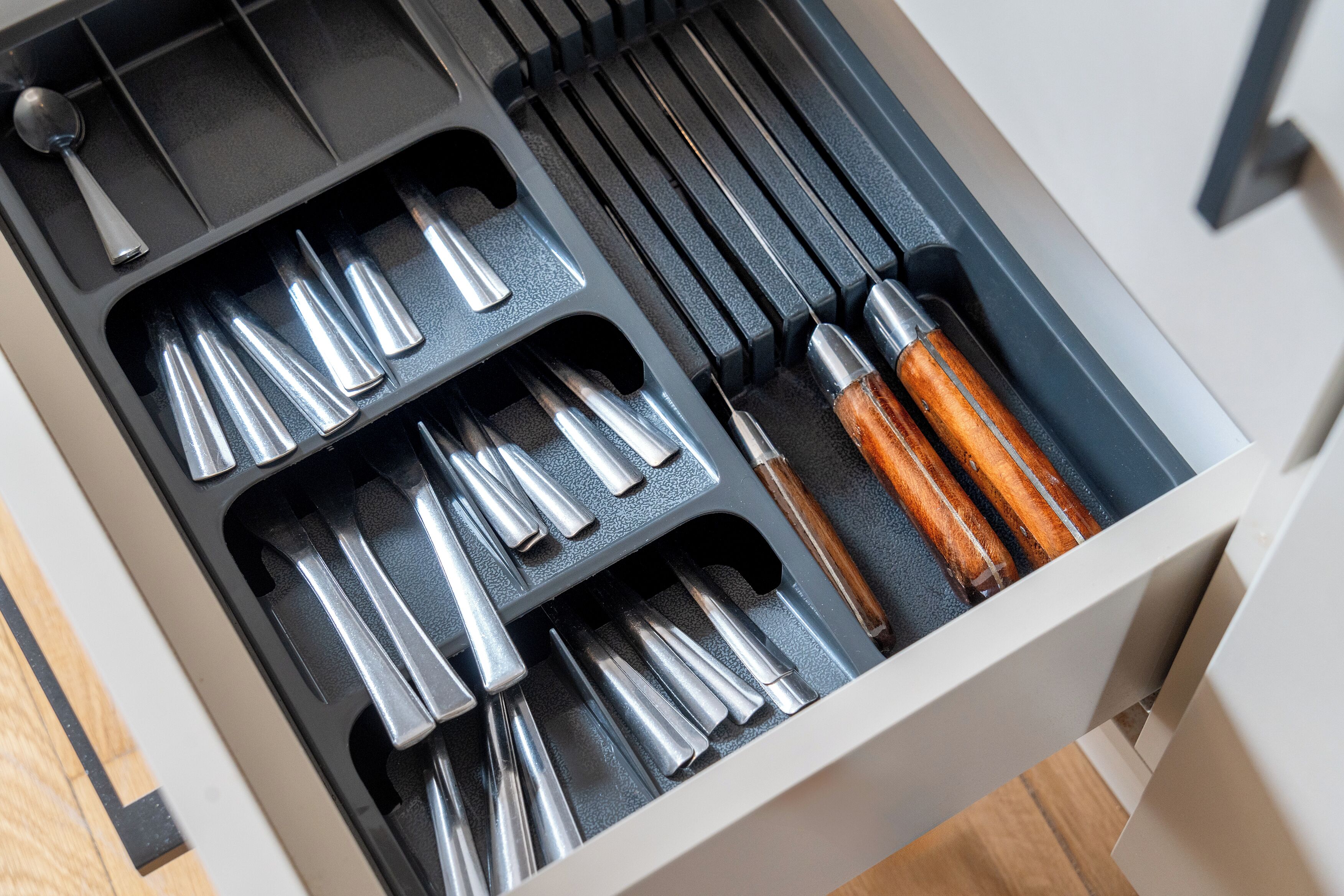A drawer with various tools, including screwdrivers and a hammer.
