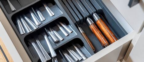A drawer with various tools, including screwdrivers and a hammer.