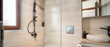 Une salle de bain moderne avec une douche à parois de verre, des toilettes et un lavabo doté d’un grand bac.
