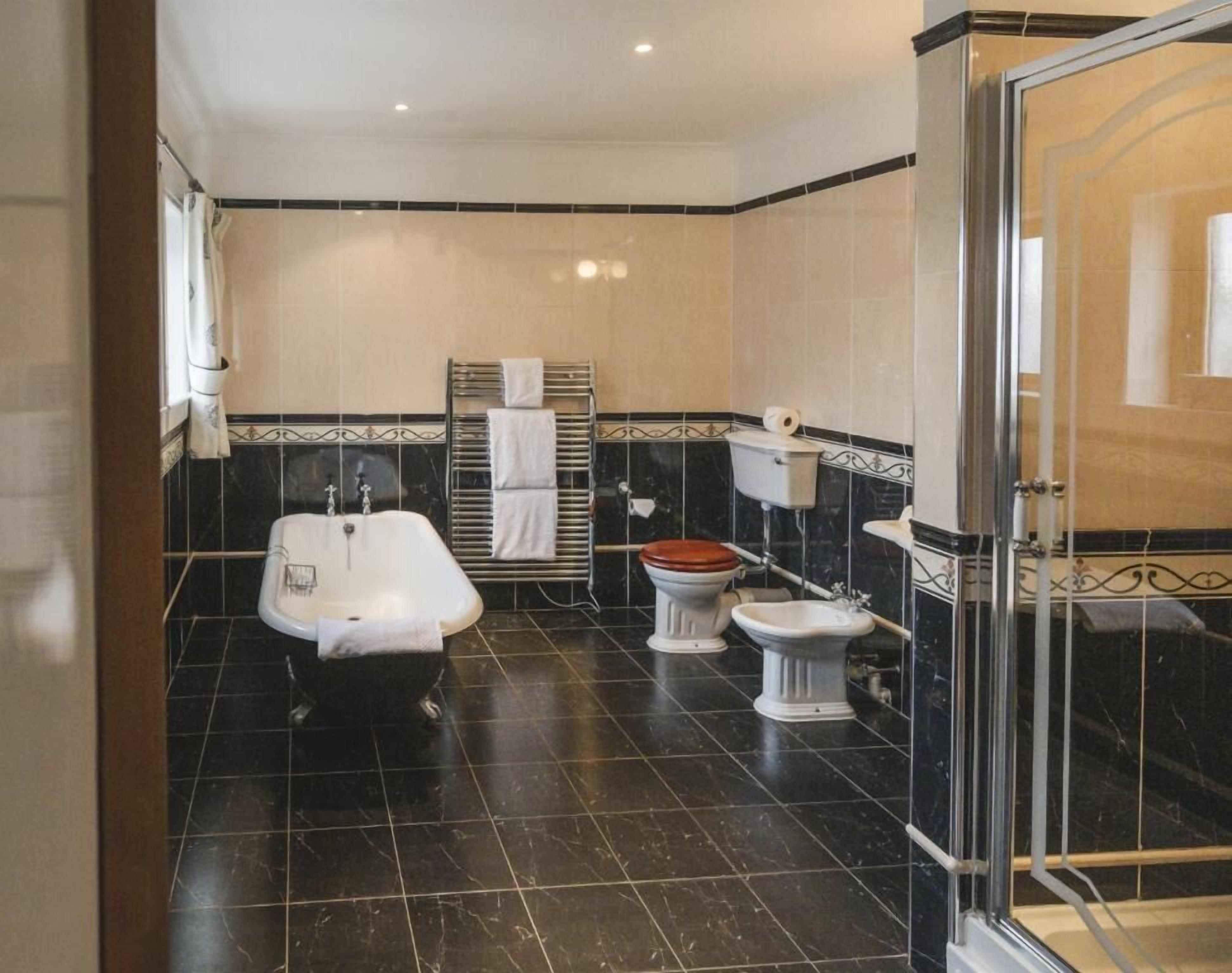 A bathroom with a bathtub, a toilet, and a bidet.