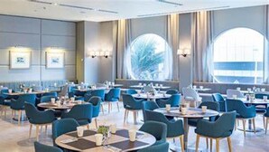 A spacious hotel dining area with multiple tables and chairs, large windows, and wall-mounted light fixtures. - 5-star, 2 bdrm apt with the perfect view of Surfers Paradise beach (Surfers Paradise)