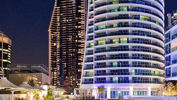 A modern hotel with a pool area, featuring a curved building with balconies and a rooftop terrace. - 5-star, 2 bdrm apt with the perfect view of Surfers Paradise beach (Surfers Paradise)