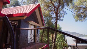 A building with a red roof and a staircase leading up to a balcony.