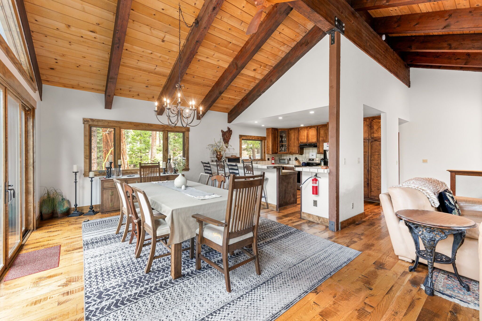 A spacious kitchen with wooden cabinets, a dining area with a table and chairs, and a cozy seating area with a sofa and a small table.