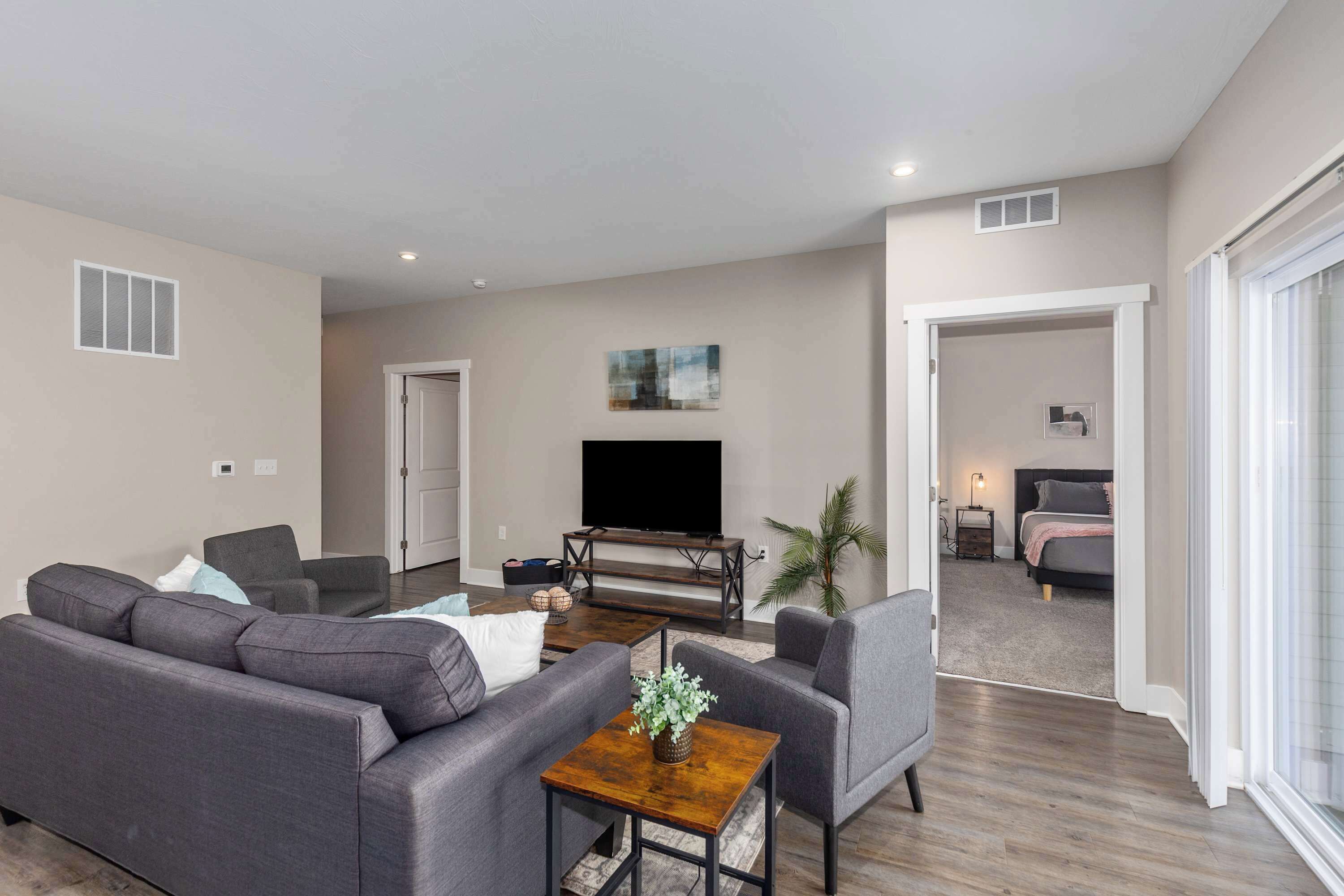 A modern living room with a grey sofa, a coffee table, and a flat-screen TV.