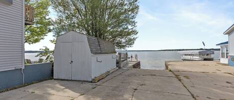 A waterfront property with a dock, a shed, and a boat.