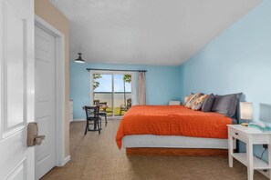 A bedroom with a bed, a desk, and a chair.