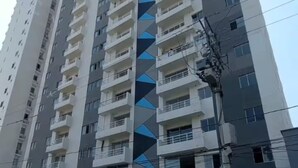A tall residential building with multiple balconies and a distinctive blue geometric pattern on the facade.
