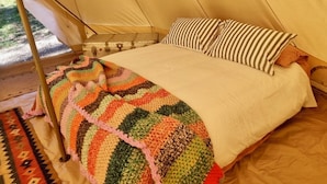 A bed with a striped pillow and a colorful blanket in a tent-like room. - Glamping nature escape at ‘Black Wattle’ 5 minutes from pristine empty beaches (Murrah)