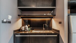 A modern kitchen with a stainless steel sink, a coffee maker, and a kettle on the countertop. - 1BR with Pool 3 Min Walk to Beach  C197 (Patong)