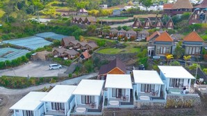 A coastal resort with multiple bungalow-style accommodations, a swimming pool, and a view of the sea. - Royal Escape (Kintamani)
