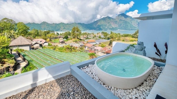 A rooftop pool with a view of a mountainous landscape and a village below. - Royal Escape (Kintamani)