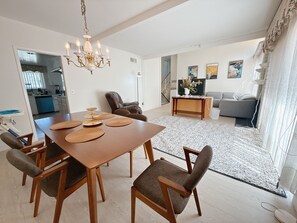 Un salon moderne comprenant une table à manger, des chaises, un canapé et une table basse.