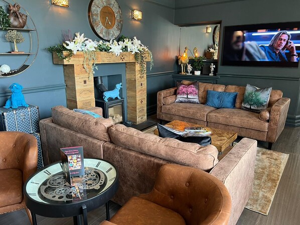 Una sala de estar con chimenea, televisor y una mesa de centro.