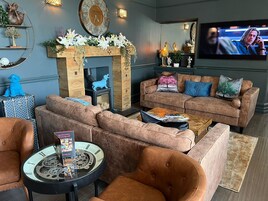 Una sala de estar con chimenea, televisor y una mesa de centro.