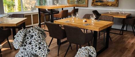 A dining area with tables, chairs, and two large knitted dog sculptures.