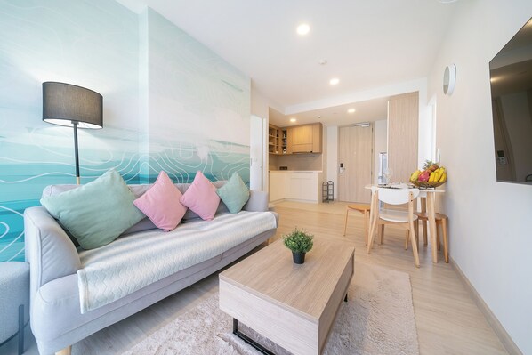 Un salon moderne avec un canapé, une table basse et un tableau accroché au mur.